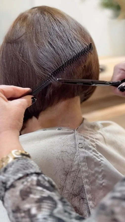 Profissional cortando cabelo curto com pente e tesoura